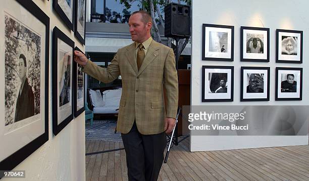 Photographer Rick Chapman adjust one of his portraits which were exhibited at a preparty for the 10th Annual ESPY Awards on July 9, 2002 at the...