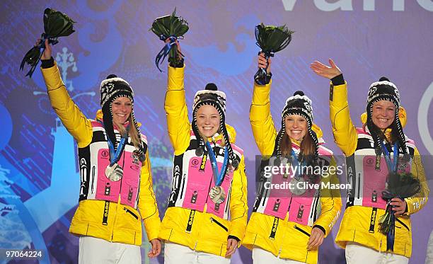 Team Germany celebrates receiving the silver medal during the medal ceremony for the ladies' 4x5 km cross-country skiing relay on day 14 of the...