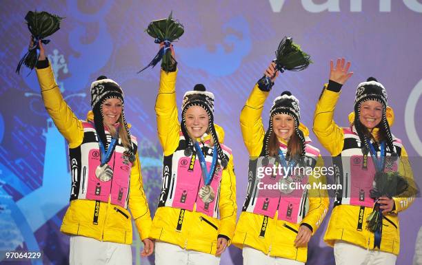 Team Germany celebrates receiving the silver medal during the medal ceremony for the ladies' 4x5 km cross-country skiing relay on day 14 of the...