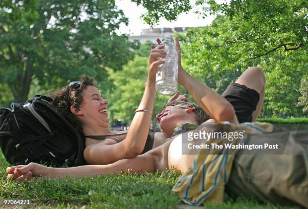Leine Grimgmuth and Mikkel Ibsen, tourists from Copenhagen, Denmark relax under the shade in Lafayette Park in Washington, D.C. Temperatures in the...