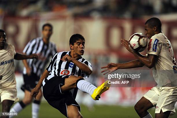 Rodolfo Gamarra from Paraguay´s Libertad vies for the ball against Jesus Rabanal from Peru´s Universitario during their Copa Libertadores football...