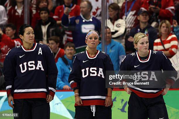 Dejected Team USA players Julie Chu, Kelli Stack and Jocelyne Lemoreux look on following their team's 2-0 defeat during the ice hockey women's gold...