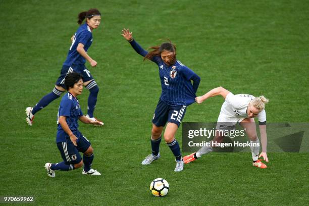 Rumi Utsugi of Japan is challenged by Betsy Hassett of New Zealand during the International Friendly match between the New Zealand Football Ferns and...