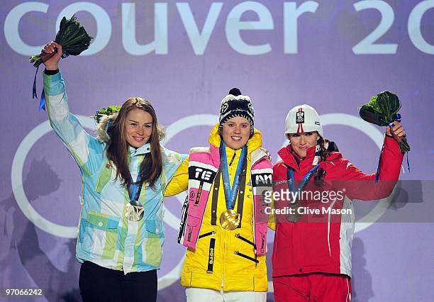 Tina Maze of Slovenia receives the silver medal, Viktoria Rebensburg of Germany receives the gold medal and Elisabeth Goergl of Austria receives the...
