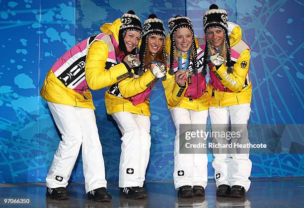 Team Germany celebrates receiving the silver medal during the medal ceremony for the ladies' 4x5 km cross-country skiing relay on day 14 of the...