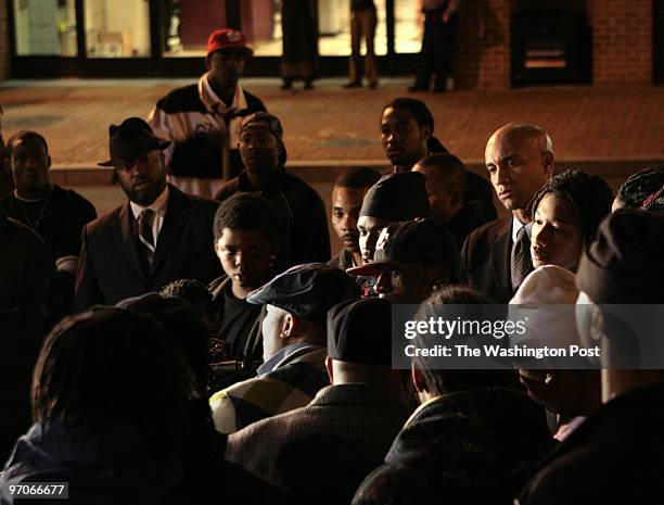 Mayor elect Adrian Fenty, at right, background, looks on as Ronald "Moe" Moten,(wearing hat, back to camera, speaks during a press conference where...