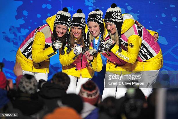 Team Germany celebrates receiving the silver medal during the medal ceremony for the ladies' 4x5 km cross-country skiing relay on day 14 of the...
