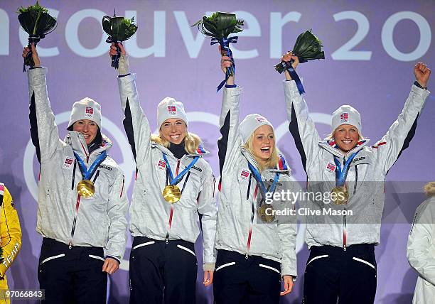 Team Norway celebrates receiving the gold medal during the medal ceremony for the ladies' 4x5 km cross-country skiing relay on day 14 of the...