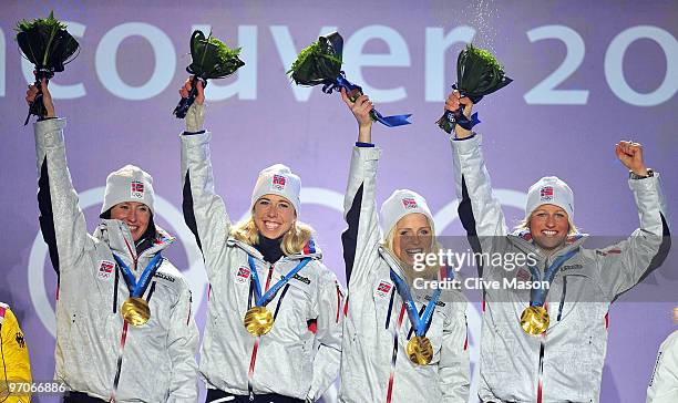 Team Norway celebrates receiving the gold medal during the medal ceremony for the ladies' 4x5 km cross-country skiing relay on day 14 of the...