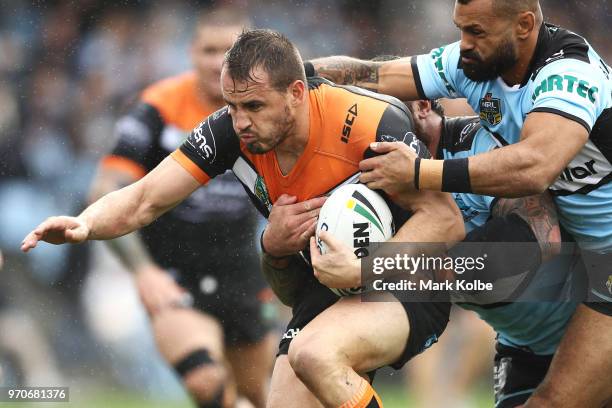 Josh Reynolds of the Tigers is tackled during the round 14 NRL match between the Cronulla Sharks and the Wests Tigers at Southern Cross Group Stadium...