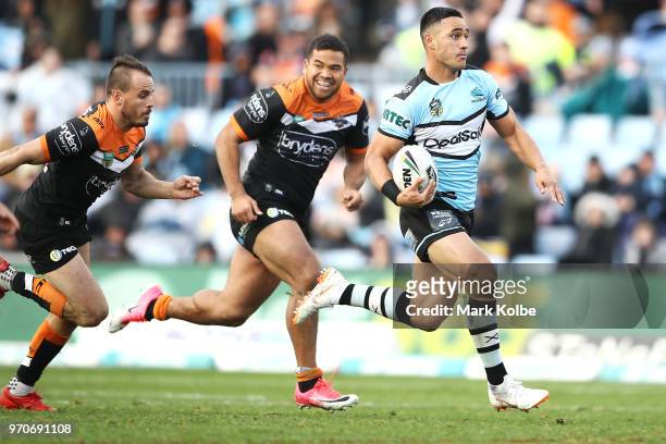 Valentine Holmes of the Sharks breaks away to score a try during the round 14 NRL match between the Cronulla Sharks and the Wests Tigers at Southern...