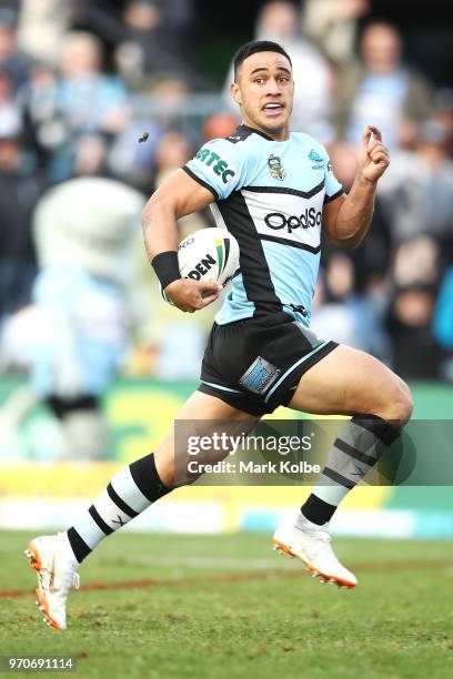 Valentine Holmes of the Sharks breaks away to score a try during the round 14 NRL match between the Cronulla Sharks and the Wests Tigers at Southern...