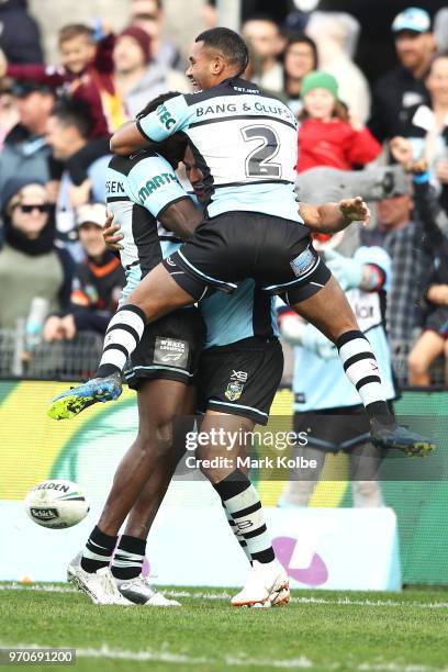 Sione Katoa, Edrick Lee and Valentine Holmes of the Sharks celebrate Holmes scoring a try during the round 14 NRL match between the Cronulla Sharks...