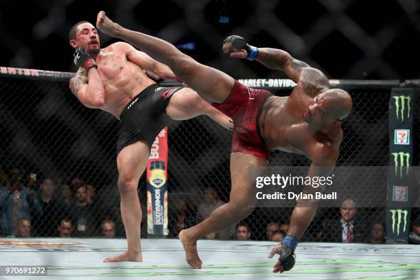 Robert Whittaker of New Zealand and Yoel Romero of Cuba each attempt a kick in the fifth round in their middleweight title fight during the UFC 225:...