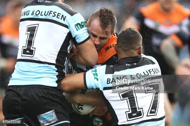 Josh Reynolds of the Tigers is tackled during the round 14 NRL match between the Cronulla Sharks and the Wests Tigers at Southern Cross Group Stadium...