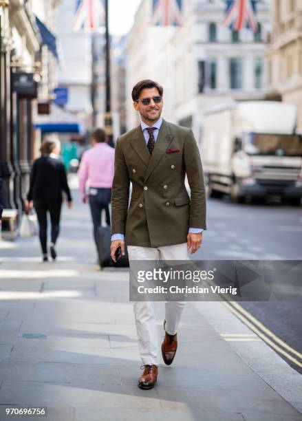 Johannes Huebl wearing green jacket, creme white pants is seen during London Fashion Week Men's June 2018 on June 9, 2018 in London, England.