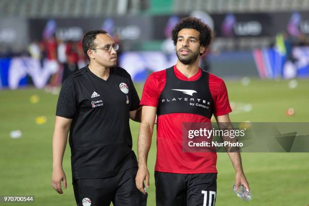 Egypt's soccer star Mohamed Salah walks with Egypt's National Team doctor Mohamed Abou El-Ela during a training session for the team in preparation...