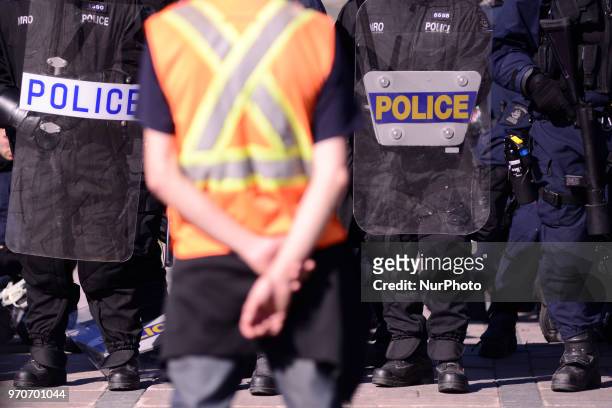 Protester wearing safety vest standing in front of the riot police during a rally to protest the G7 summit in Quebec City, Canada on 9 June 2018....