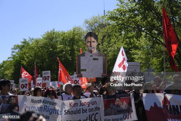 Protesters with a cut out of Justin Trudeau during a rally to protest the G7 summit in Quebec City, Canada on 9 June 2018. During the last day of the...