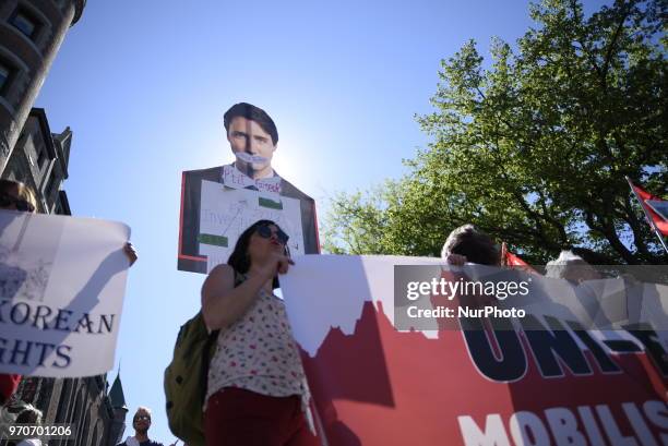 Protesters with a cut out of Justin Trudeau during a rally to protest the G7 summit in Quebec City, Canada on 9 June 2018. During the last day of the...