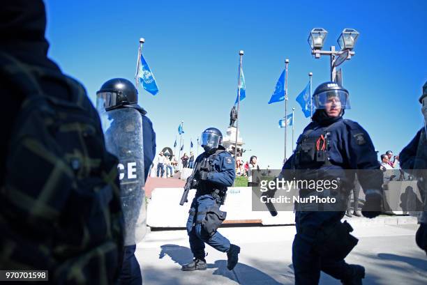 Riot police with pepper spray and tear gas gun following the people during a rally to protest the G7 summit in Quebec City, Canada on 9 June 2018....