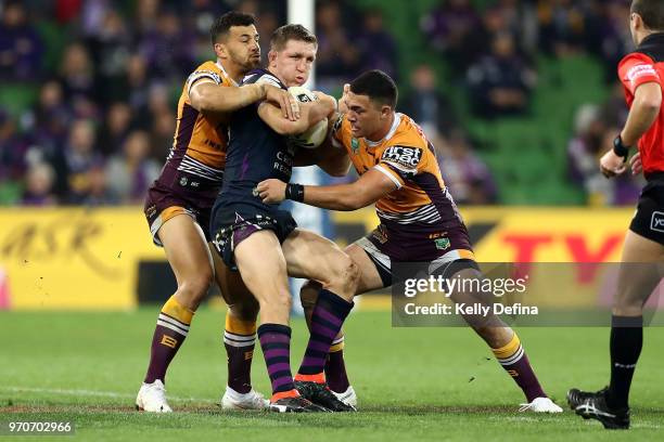 Ryan Hoffman of the Storm is tackled by Broncos defense during the round 14 NRL match between the Melbourne Storm and the Brisbane Broncos at AAMI...