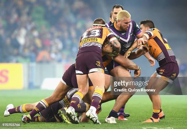 Nelson Asofa-Solomona of the Storm is tackled during the round 14 NRL match between the Melbourne Storm and the Brisbane Broncos at AAMI Park on June...