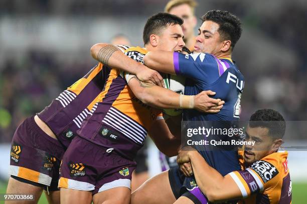 Young Tonumaipea of the Storm is tackled during the round 14 NRL match between the Melbourne Storm and the Brisbane Broncos at AAMI Park on June 10,...