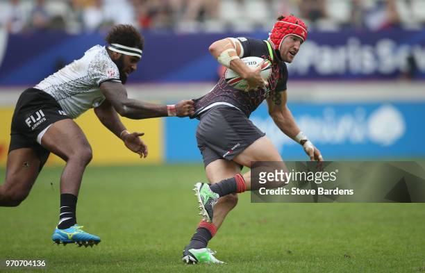 Phil Burgess of England is tackled by Semi Kunatani of Fiji during the Cup quarter final match between Fiji and England during the HSBC Paris Sevens...