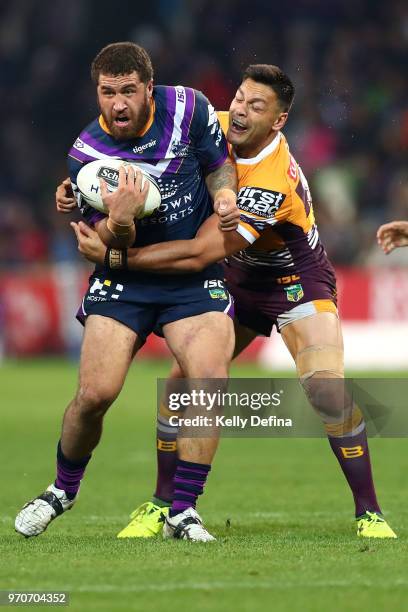 Kenneath Bromwich of the Storm is tackled by Broncos defense during the round 14 NRL match between the Melbourne Storm and the Brisbane Broncos at...