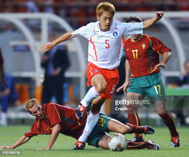 Korea's Kim Nam Il vies for the ball with Portugal's Frechaut as Paulo Bento follows, 14 June 2002 at the Incheon Munhak Stadium in Incheon, during...