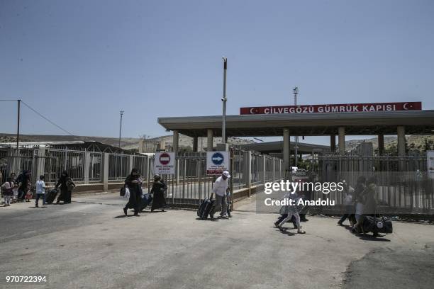 Syrians are seen with their belongings as they wait to return to Syria ahead of Eid al-Fitr at the Cilvegozu border gate in Reyhanli of Hatay, Turkey...