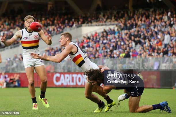 David Mackay of the Crows gets his handball away while being tackled by Alex Pearce of the Dockers during the round 12 AFL match between the...