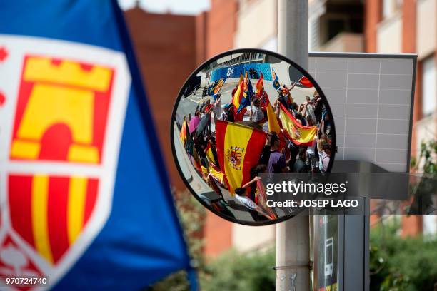 People holding Spanish flags are reflected on a miror during a demonstration called by far-right groups under the slogan "For the closure of TV3" in...