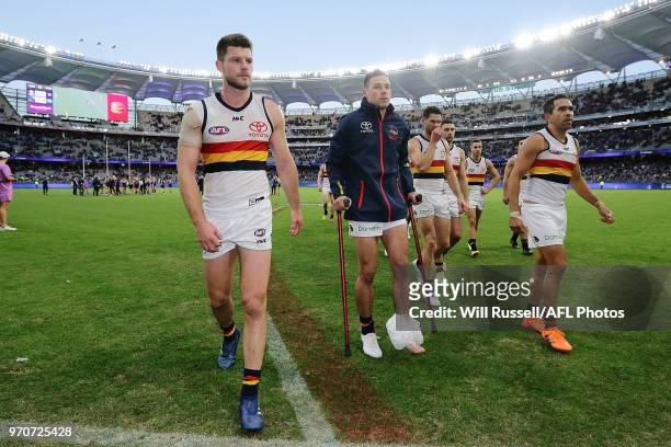Injured Luke Brown of the Crows leaves the field on crutches after the teams defeat during the round 12 AFL match between the Fremantle Dockers and...