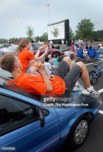 Fx-stand9 assignmet no: 193081 Photographer: Gerald Martineau 5875 Trinity Parkway Centerville, VA outdoor movies Enjoying pizza on the hood of her...