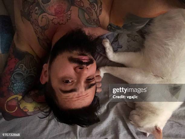 mann mit weiße katze im bett - cat selfie stock-fotos und bilder