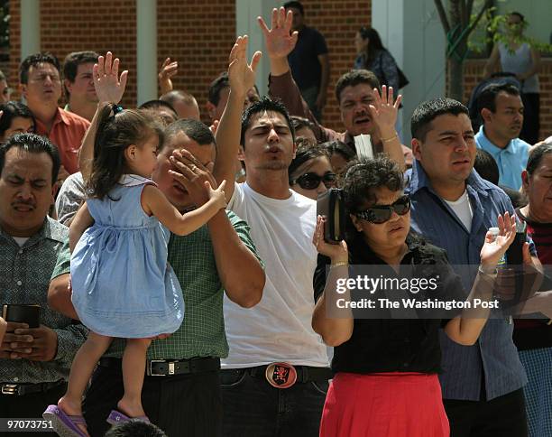 Woodbridge, Virginia Jose Garcia, of Manassas, holding his daughter Denise Garcia wipes away a tear during a prayer rally organized by the National...