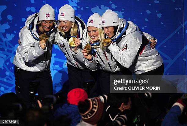 Norwegian gold medallists Vibeke Skofterud, Therese Johaug, Kristin Stoermer Steira and Marit Bjoergen celebrate on the podium during the medal...