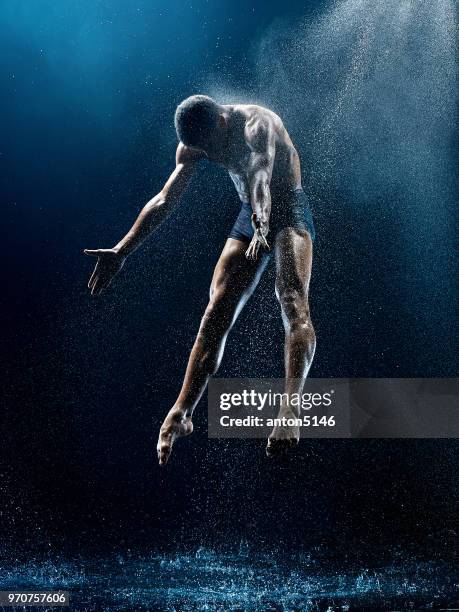 athletic ballet dancer performing with water - african ballet stock pictures, royalty-free photos & images
