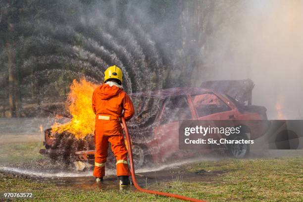 los bomberos luchar contra una operación de fuego, spray de agua por boquilla de alta presión al fuego envolvente con humo, los bomberos apagan un coche - carro de bombeiro fotografías e imágenes de stock