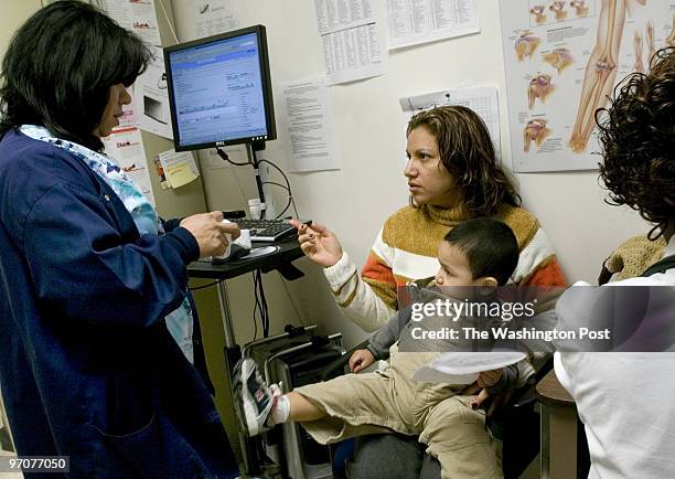 Mococares Date: 2.14.2008 Kevin Clark/TWP Neg #: 198120 Wheaton, MD Sonia Reyes, left, talks with patient Ana Maritza Trejo with son Derek Funes...