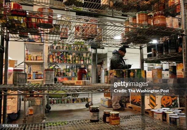 Taylor Street, NE Volunteer Robert H. Coats, of Washington, D.C., help to restock the shelves with donated food at the Capital Area Food Bank stock...