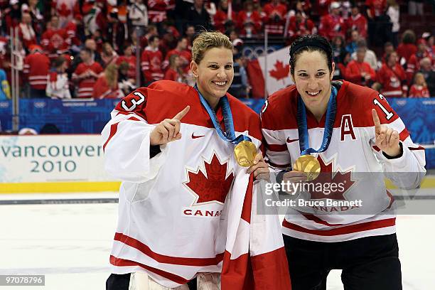 Kim St-Pierre and Caroline Ouellette of Canada pose with the gold medals won during the ice hockey women's gold medal game between Canada and USA on...