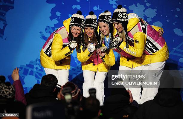 German silver medallists Katrin Zeller, Evi Sachenbacher-Stehle, Miriam Gossner and Claudia Nystad celebrate on the podium during the medal ceremony...