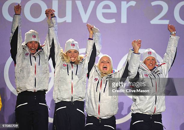 Team Norway celebrates receiving the gold medal during the medal ceremony for the ladies' 4x5 km cross-country skiing relay on day 14 of the...
