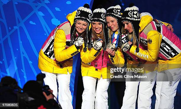 Team Germany celebrates receiving the silver medal during the medal ceremony for the ladies' 4x5 km cross-country skiing relay on day 14 of the...