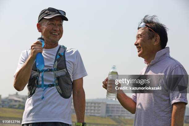 ich nehme eine pause mit meinen jogging-begleiter und versorgung hydratation. - kazunoriokazaki stock-fotos und bilder