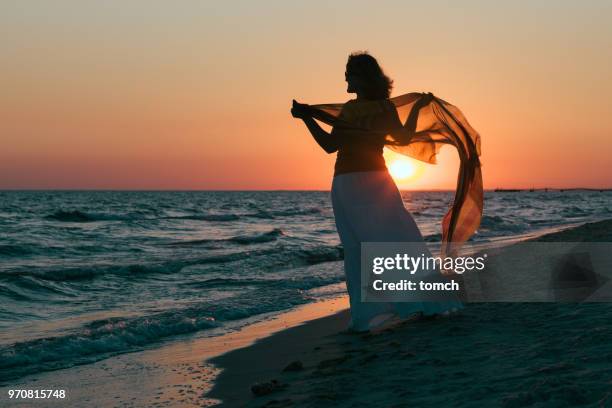uma mulher solitária em crepúsculo - língua de areia - fotografias e filmes do acervo