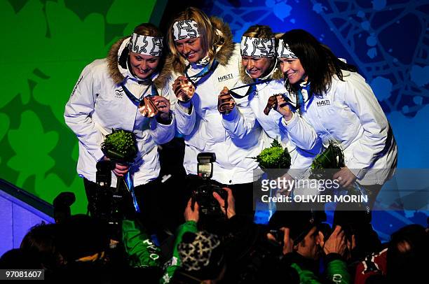 Finland's bronze medalists Janne Ryynaenen, Jaakko Tallus, Anssi Koivuranta and Hannu Manninen celebrate on the podium during the medal ceremony for...